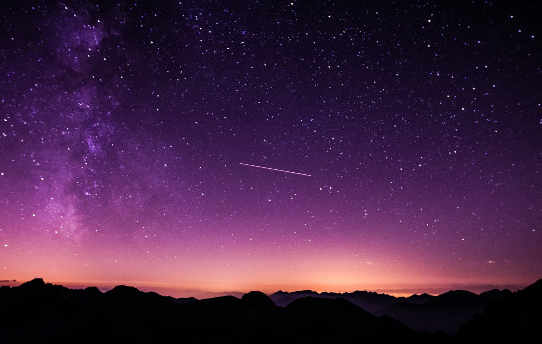A night sky over a dark landscape.