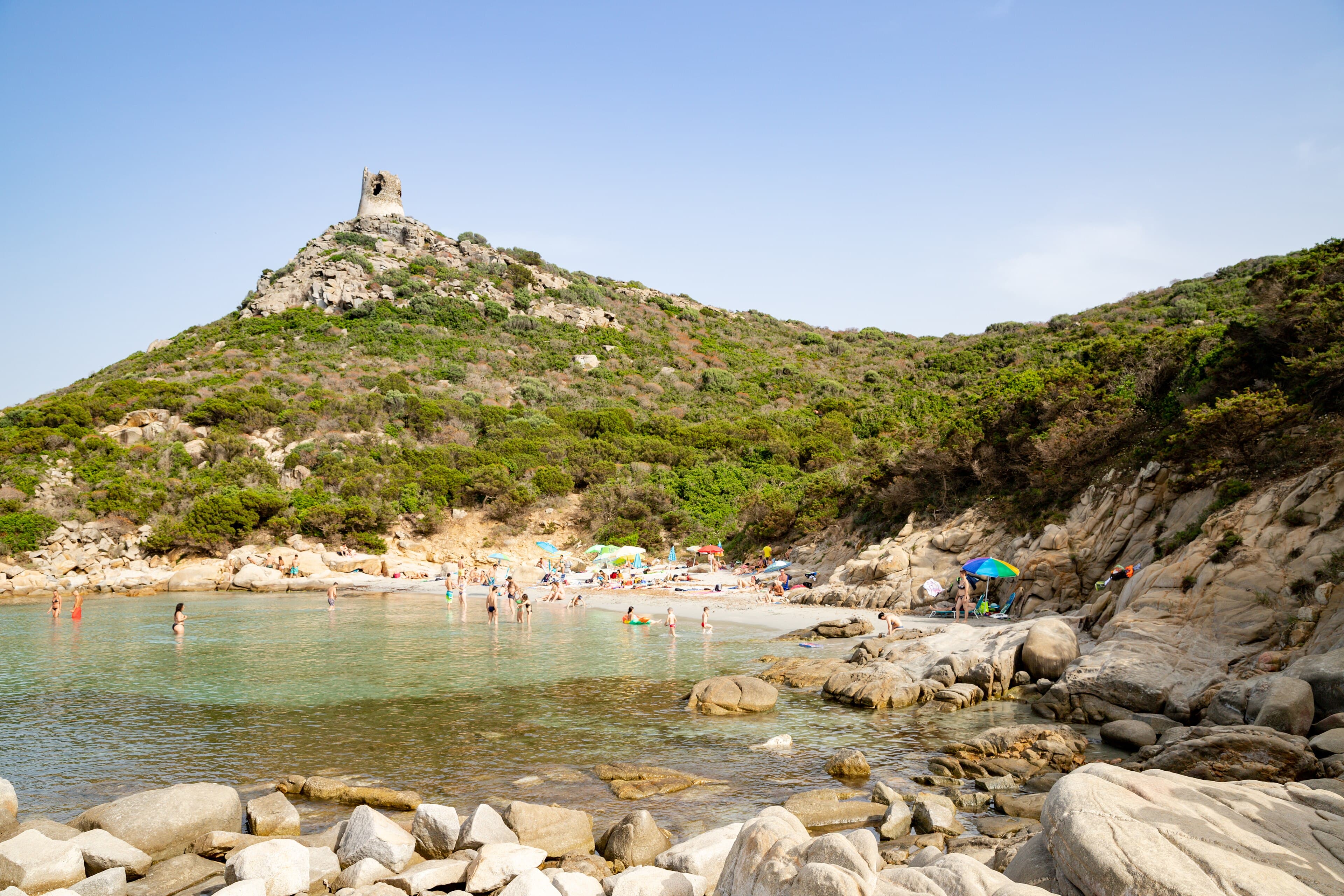 The shore beneath the Porto Giunco tower at a quieter hour.